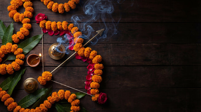 Marigold garlands, rose petals, incense smoke, oil lamp on dark wood, Diwali festive arrangement, Indian ritual decor, spiritual celebration, copy space, suitable for editorial themes,