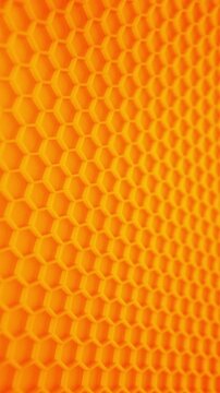 Orange Honeycomb Pattern Background. Macro view of bright orange hexagonal surface with subtle depth and smooth motion for abstract technology background.