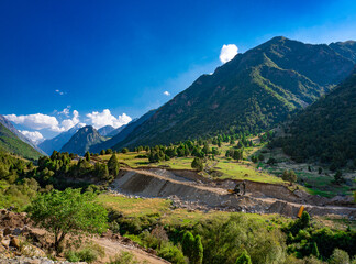 Road construction and excavation works in a mountain valley. Infrastructure development in remote region. © Aleksandr.Kai