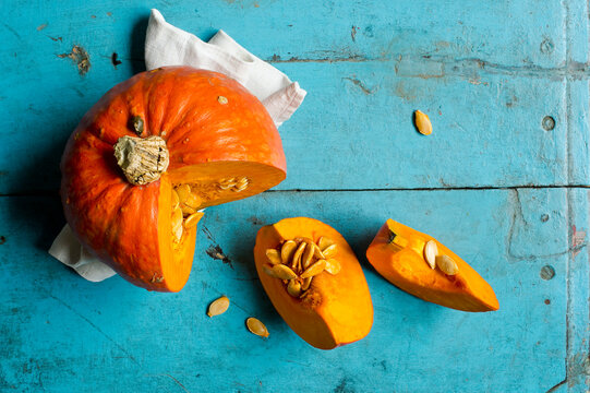 Red kuri squash (Cucurbita maxima) on blue cutting board