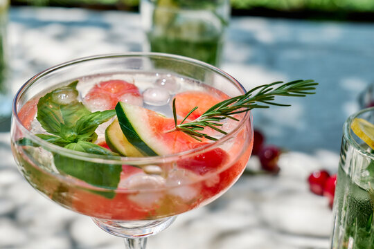 A refreshing watermelon cocktail sits on an outdoor table in summer