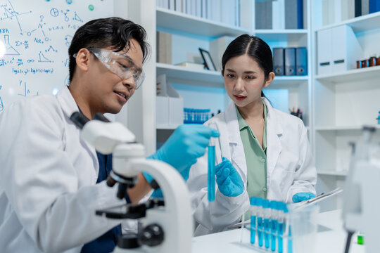 Scientists perform laboratory experiments using microscopes, pipettes and test tubes while analyzing samples in modern research laboratory, representing biotechnology, diagnostics and medical science.