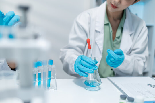 Scientists perform laboratory research using microscopes, test tubes, and modern scientific equipment to analyze samples, representing biotechnology, healthcare, diagnostics, and medical innovation.