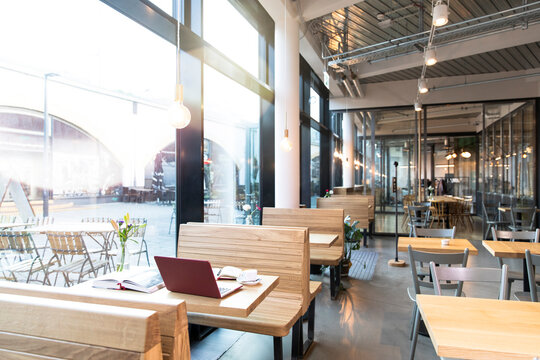 Laptop and books on table in a modern cafe