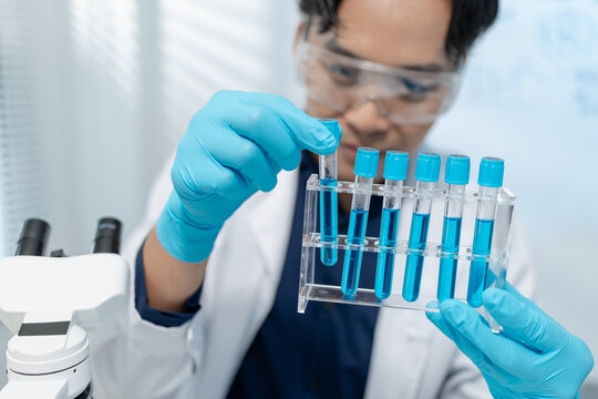 Scientists analyze liquid samples using test tubes, microscopes, and laboratory equipment, representing biotechnology, medical diagnostics, research, and healthcare innovation.