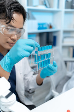 Scientists analyze liquid samples using test tubes, microscopes, and laboratory equipment, representing biotechnology, medical diagnostics, research, and healthcare innovation.