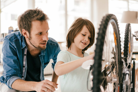 Father and son repairing bicycle together at home