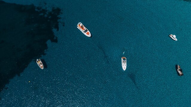 A drone captures motorboats anchored in the blue sea of Sardinia