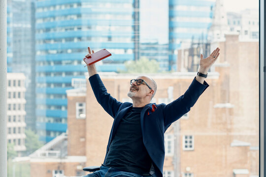 Businessman celebrating success with arm raised in London office