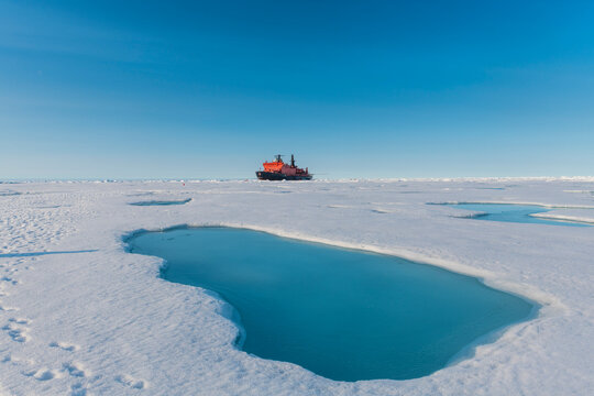 Aerial view of melting ice on North Pole with ice-breaker 50 Years of Victory in background