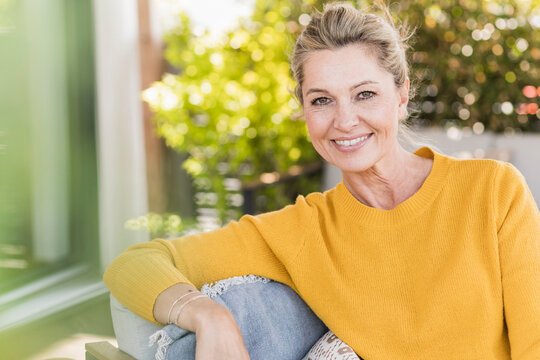 Portrait of smiling mature woman sitting on terrace