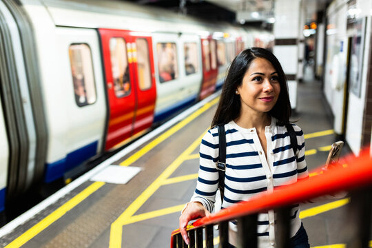Smiling woman moving up on staircase at subway station