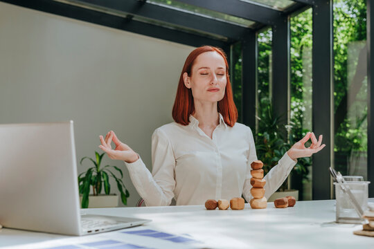 Businesswoman with eyes closed meditating at desk in office