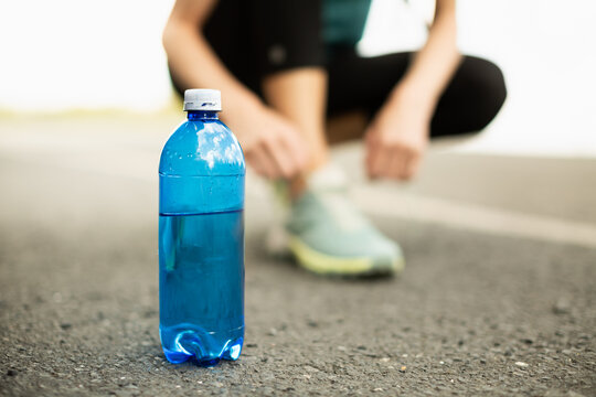 Drinking Water Bottle On Road Before Summer Run Highlighting Hydration And Staying Hydrated During Heatwave
