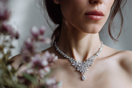 Close-up portrait of a woman wearing an ornate diamond necklace in a studio. Luxury jewelry, elegance, glamour, fashion, bridal, celebration, beauty, luxury lifestyle.