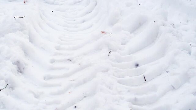 A close-up of truck tire tracks. Deep tire marks from a heavy vehicle in the snow and dirt. Winter background.