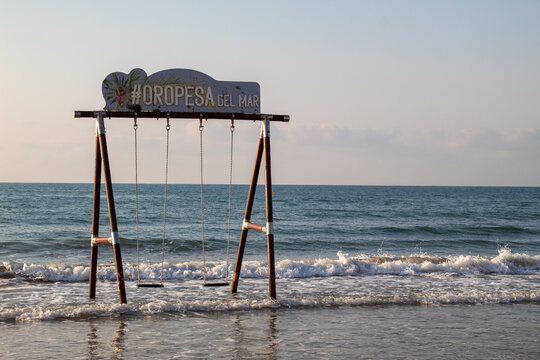Wooden swing in the Mediterranean Sea at La Concha Beach, Oropesa del Mar, Spain