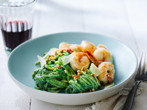 Shrimp pasta with basil pesto and pine nuts served with red wine, fine dining menu, gourmet experience