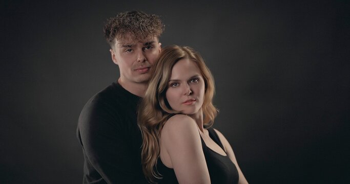 Young couple embracing, showing relationship and togetherness in studio