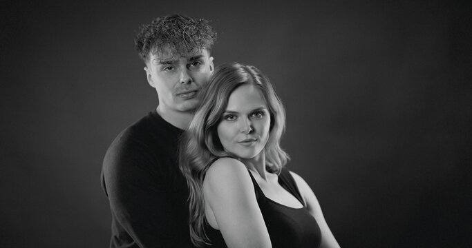 Young man and woman posing together in a studio, showing intimacy and connection