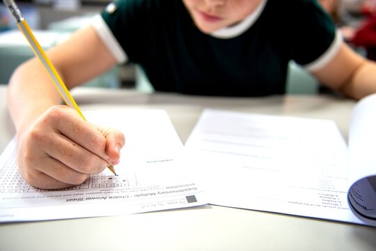 Student filling out a multiple-choice test with a pencil.