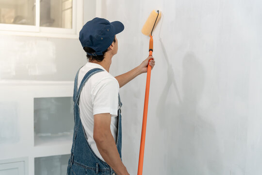 painter man, brush in hand for products to restore and paint the wall, indoor the building site of a house, wall during painting, renovation, painting, contractor, Architect, construction worker