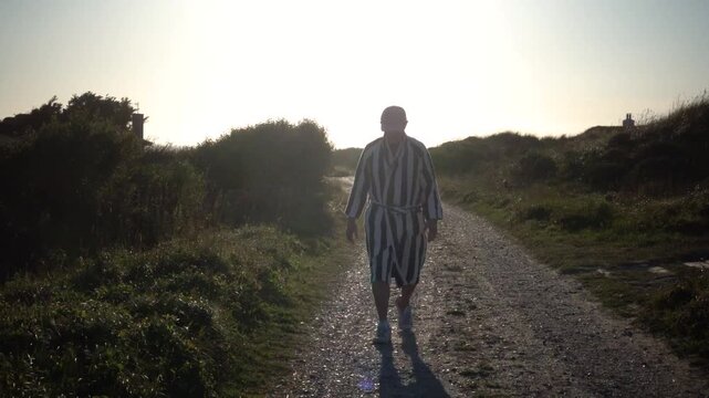 Hirtshals, Denmark A man walks in the sandy and grassy North Sea dunes at sunset. 