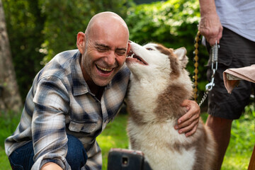 Joyful man with affectionate husky © Rawpixel.com