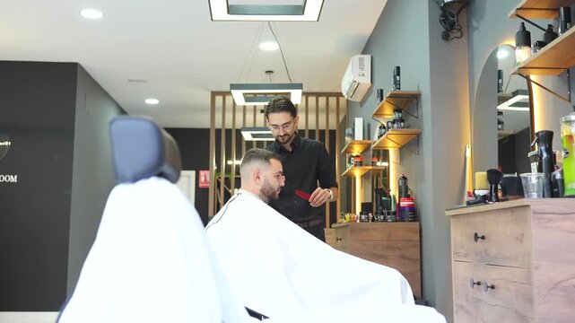 Professional barber styling a man's hair with a comb and clippers in a modern barbershop