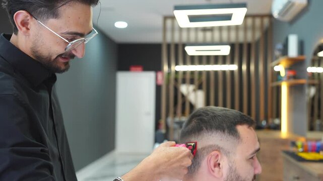 Professional barber meticulously trimming a client's hair with a modern electric razor