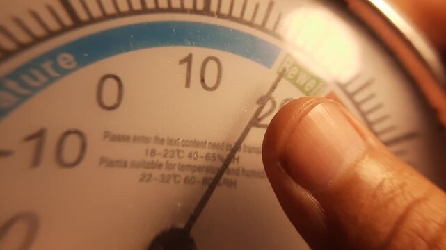 Macro shot of a person holding a professional climate measuring instrument to check the room's temperature and humidity levels for home comfort