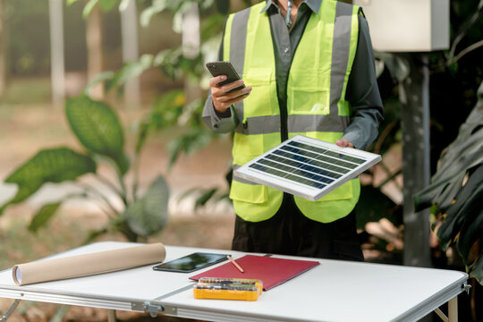 Engineer checks solar cell electrical cabinet wiring outdoors in field