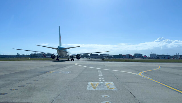 Commercial Airplane Taxiing on Tarmac at Sydney Airport Under Blue Sky