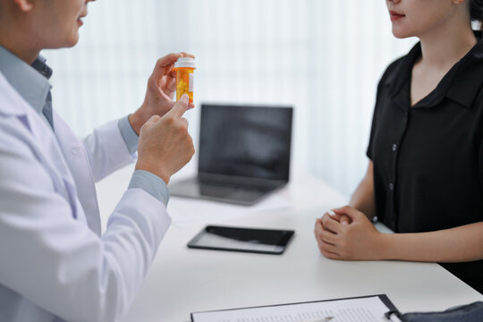 doctor explain drug bottle instructions with a patient in a hospital office
