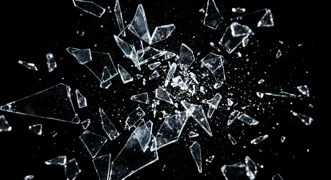 Shattered glass exploding outwards into sharp flying fragments isolated on black background in high speed photography