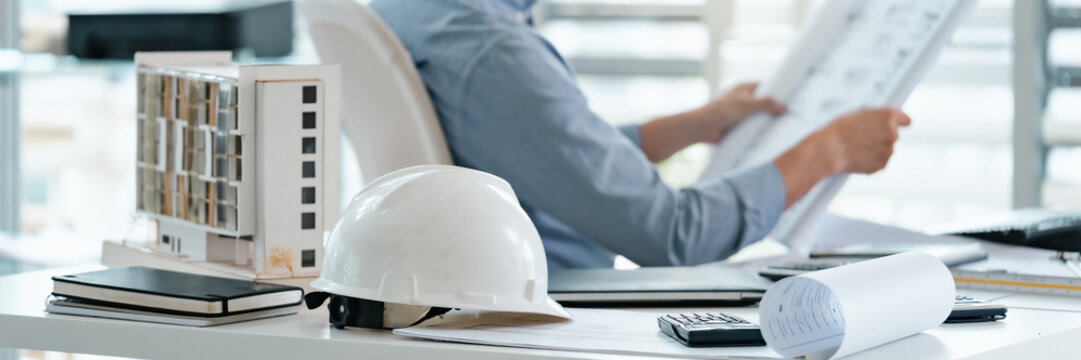 Site engineer planning projects with blueprint in indoor office