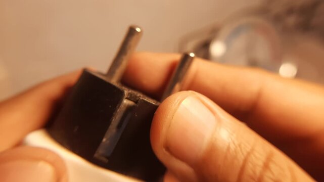 Close Up of Detail Macro Finger Holding EU Electrical Power Plug