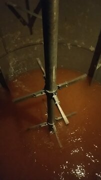 Industrial Chemical Reactor Mixing Process with Stirrer Agitator Blending Orange Liquid