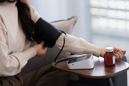 woman monitoring health with blood pressure device