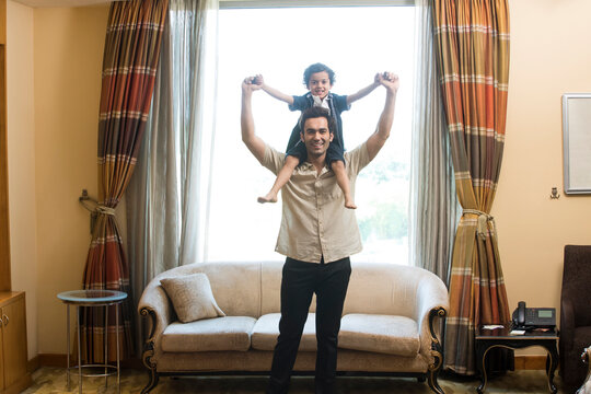 Dad and son on his shoulders playing 