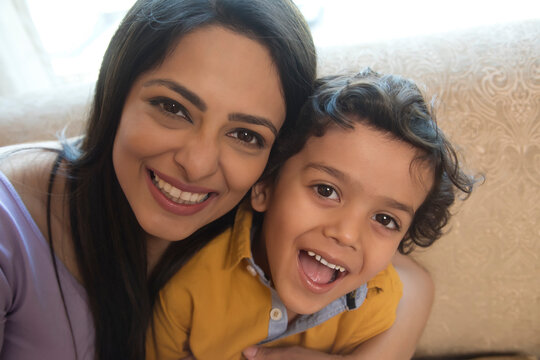 Close-up portrait of mother and daughter smiling