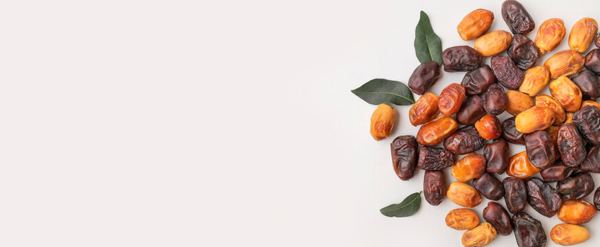 Healthy dried dates scattered on light gray background, natural fruit assortment creates clean overhead composition. Healthy food imagery supports wellness marketing, nutrition content and lifestyle 
