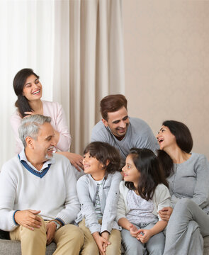 Multi-generation family sitting on sofa in living room