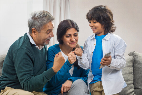 Grandparents and grandson showing fist and smiling