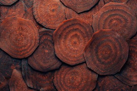 Macro view of thinly sliced raw dark beetroots showing natural rings. Perfect background for healthy eating, autumn recipes, vegan food marketing, and organic texture concepts