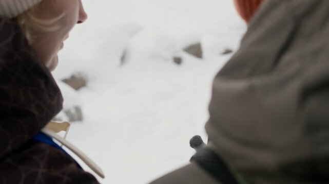 Caucasian middle-aged man and woman checking navigation map on smartphone during winter hike, then looking at snowy landscape and smiling. Ideal for winter tourism and travel app promotions
