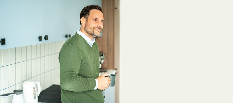 Mature man holding coffee mug, taking break, contemplating success, managing business, enjoying kitchen moment, reflecting on legal or accounting career, professional looking away