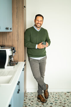 Business professional smiling and enjoying a coffee break in a contemporary office setting, portraying a successful and confident individual in a corporate environment