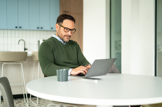 Male professional working on a laptop. Managing business operations. Legal documents. And financial records