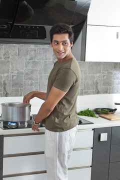 Young man cooking food in kitchen